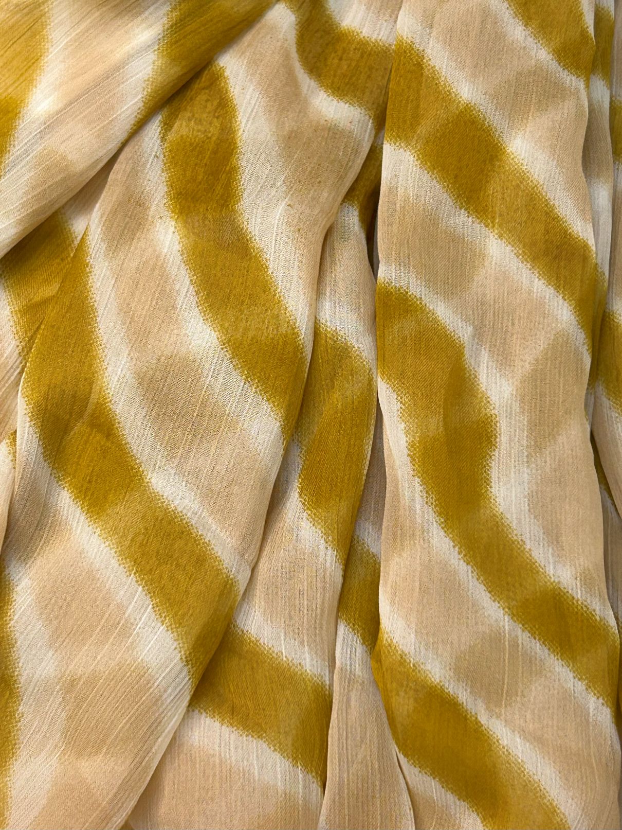 Close-up of chiffon dupatta with yellow and beige wavy pattern